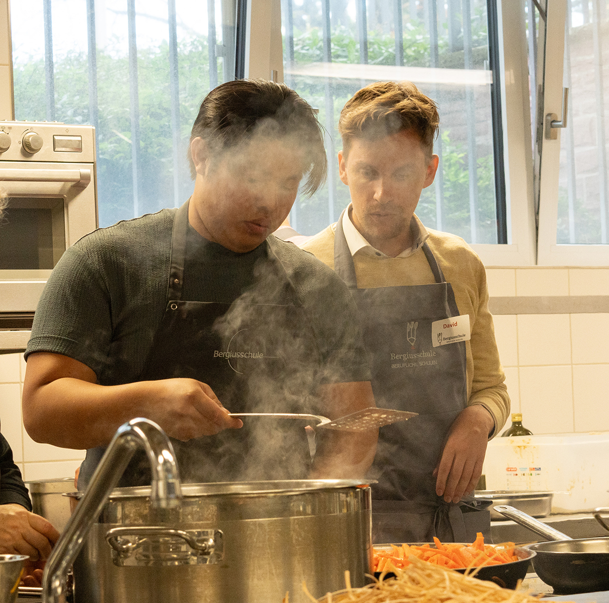 Menschen beim gemeinsamen Kochen am Herd